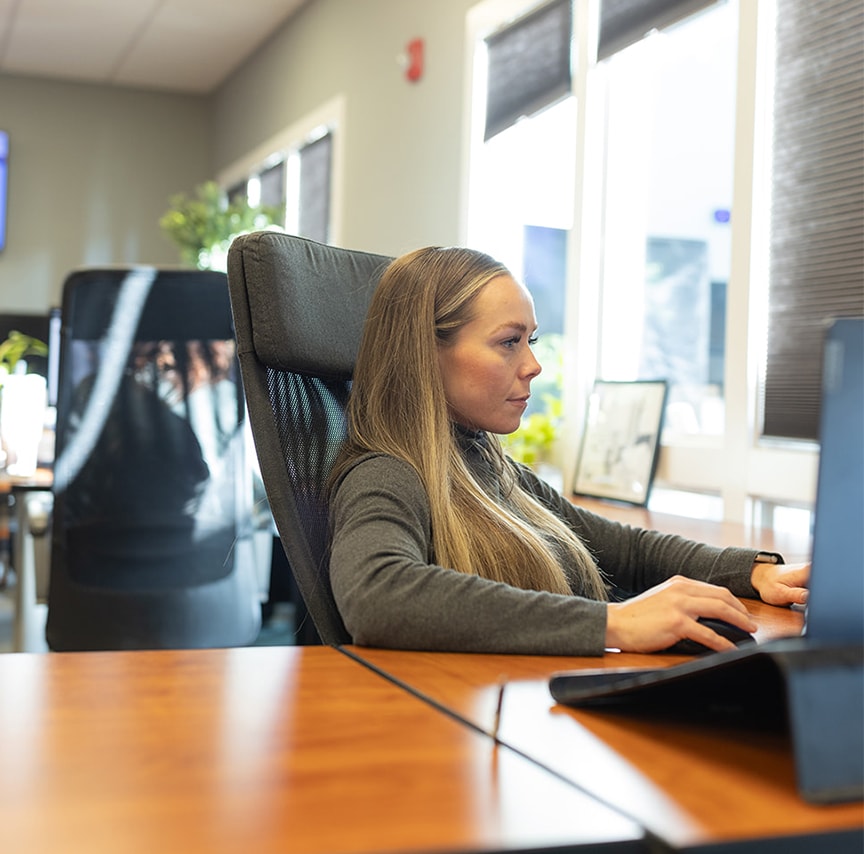 close-up of woman working on her computer at her desk